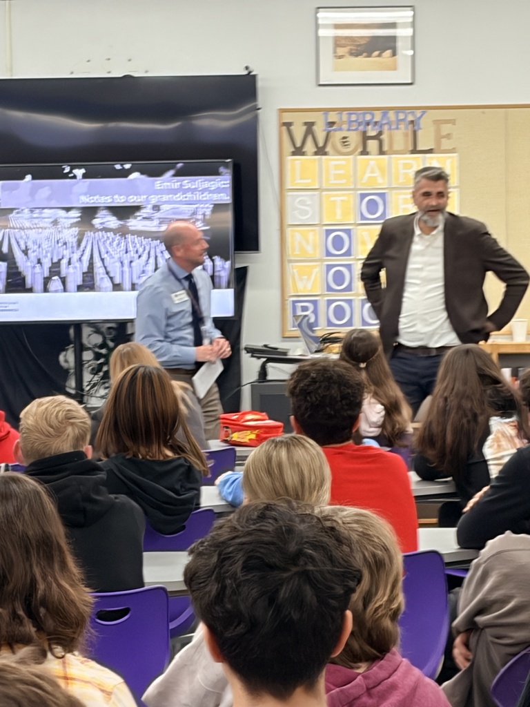 Affton Superintendent Dr.Travis Bracht stands next to guest speaker Emir Suljagić in a library setting to welcome him..