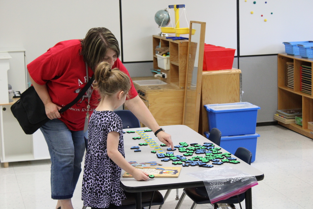 Teacher with student and letters on table