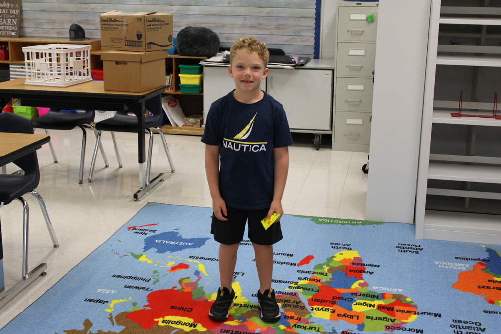 Afton student on top of a map of the world