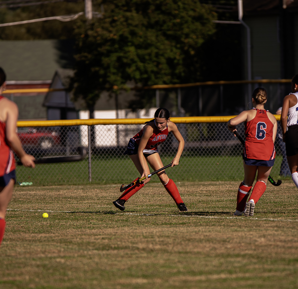Afton player in action with field hockey stick
