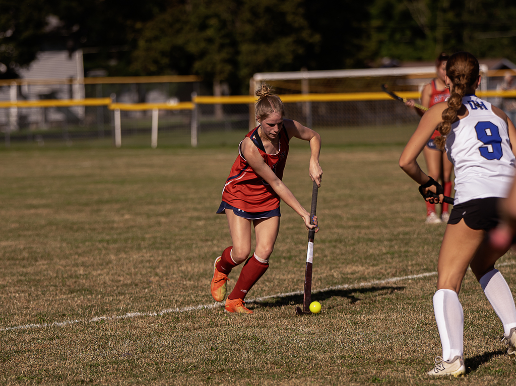 Afton player in action with field hockey stick
