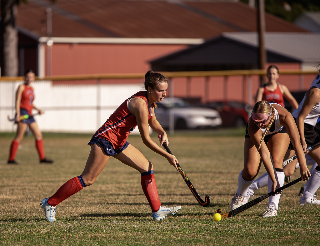 Afton player in action with field hockey stick