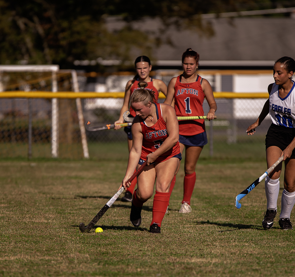 Afton player in action with field hockey stick