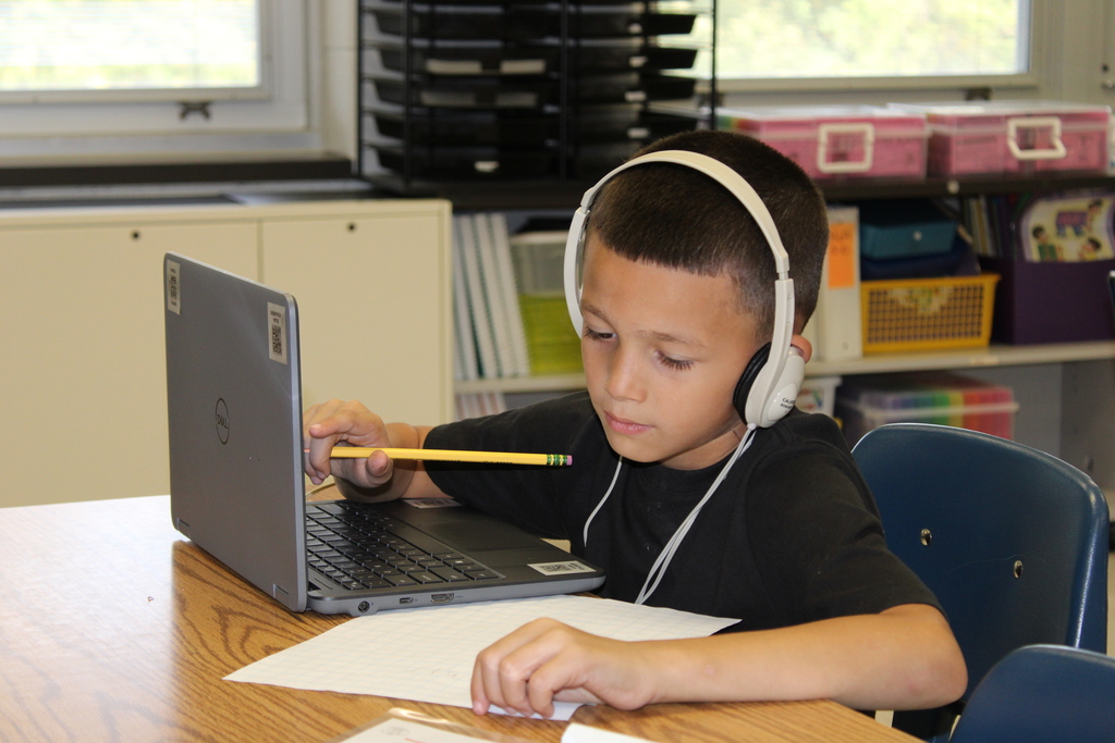 Afton student with computer and paper