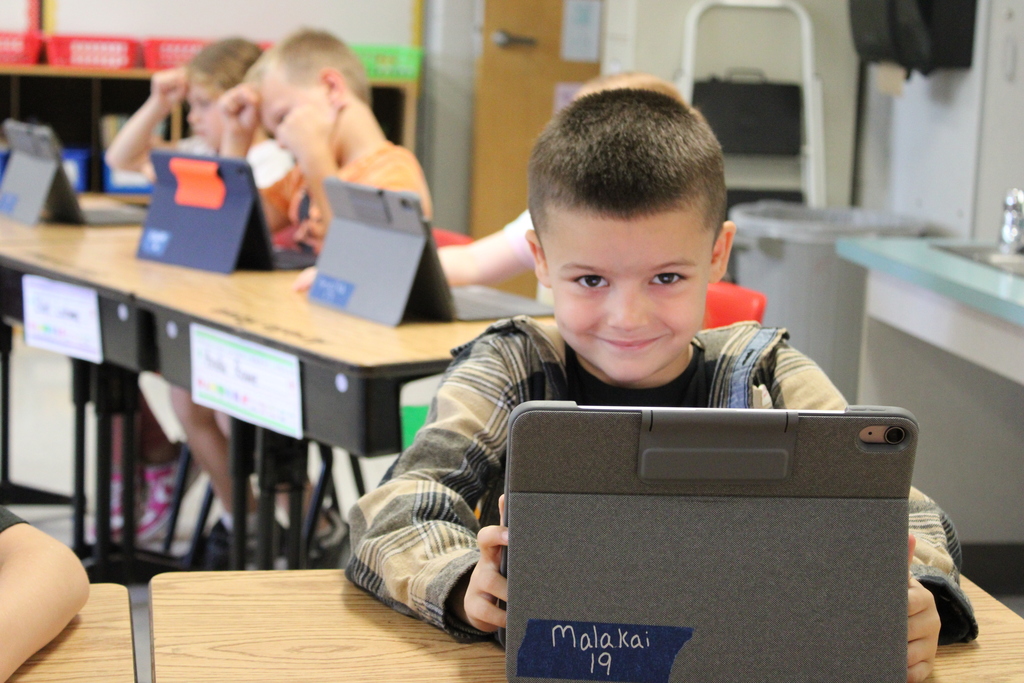 Afton student smiling with tablet