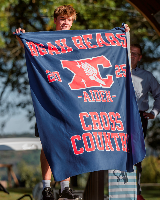 Bears Cross Country flag with student holding the flag