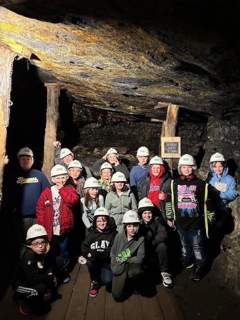 Students group photo with mining hats on under ground