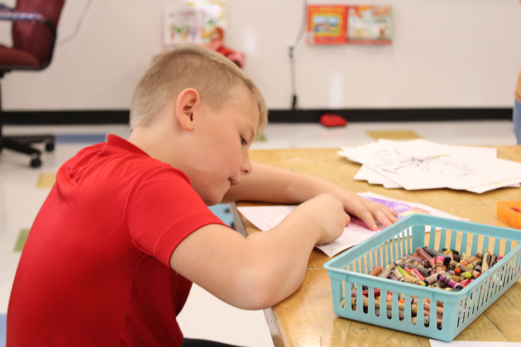 Student coloring with crayons