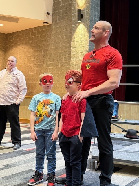 Guest speaker with boys dressed as super heros
