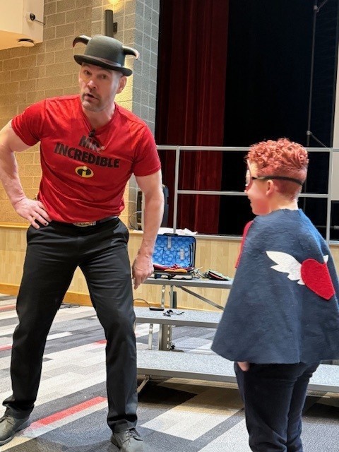 Guest speaker with boy in cape