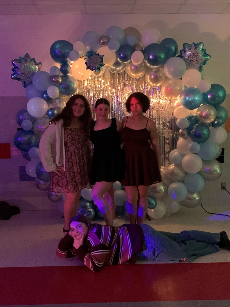 Students standing for photo op one is lying on the floor.