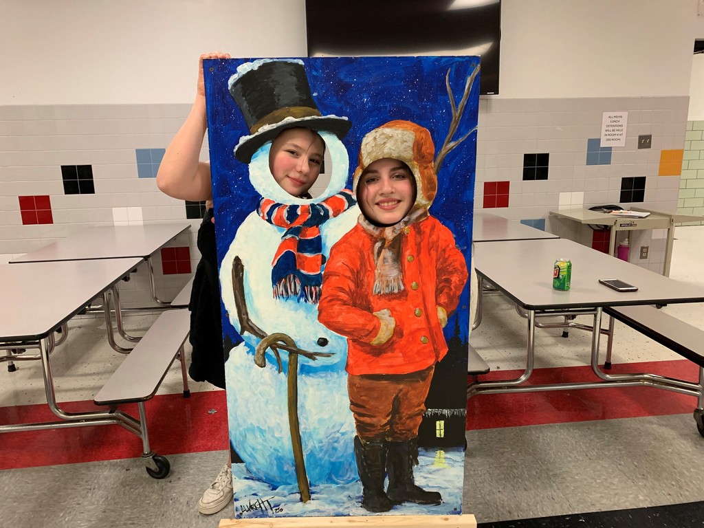 Students in front of a snowman and winter weather man photo op cutout