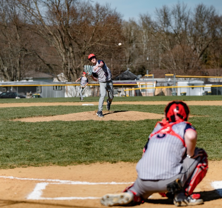 varsity player and catcher with the ball