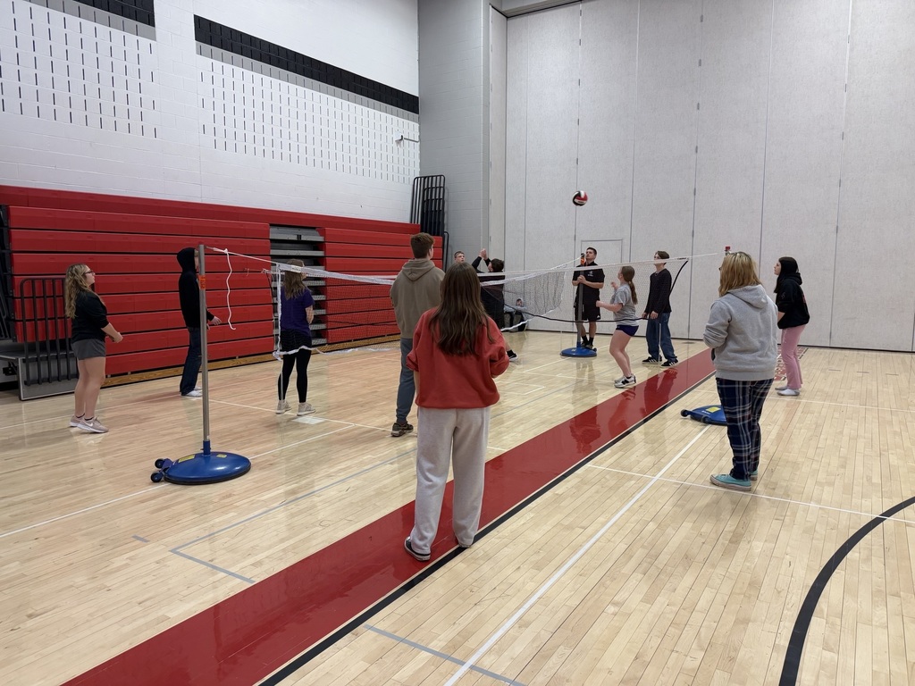 students playing four-square volleyball