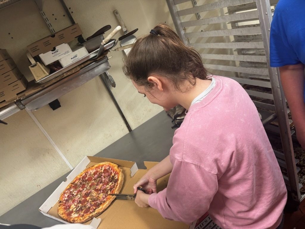 Student putting pizza in a box