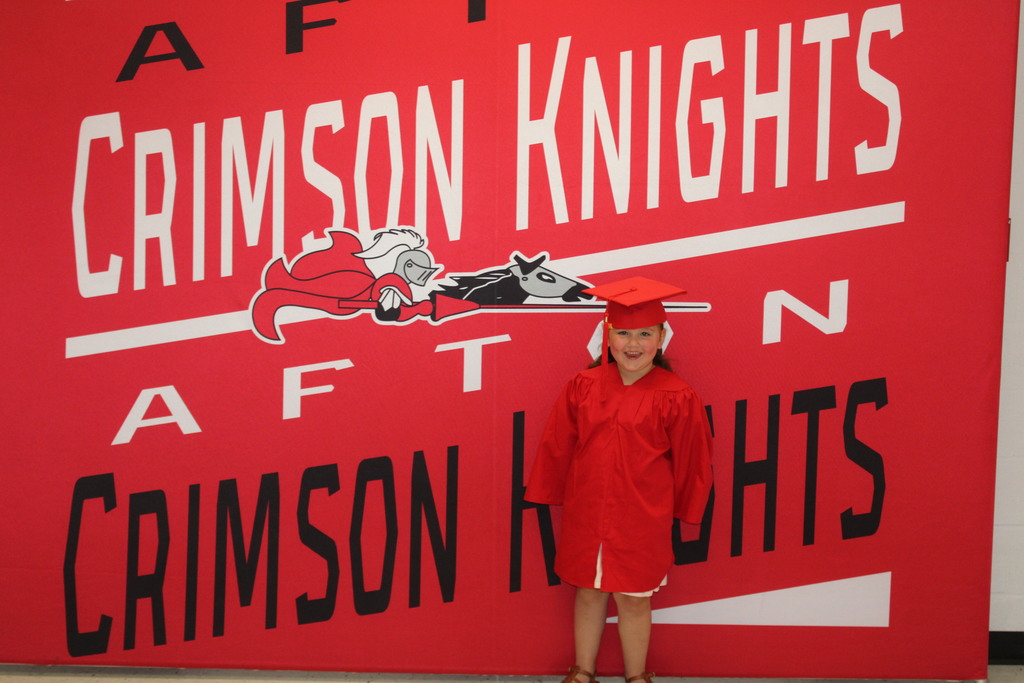 Afton student in front of Crimson Knight Banner