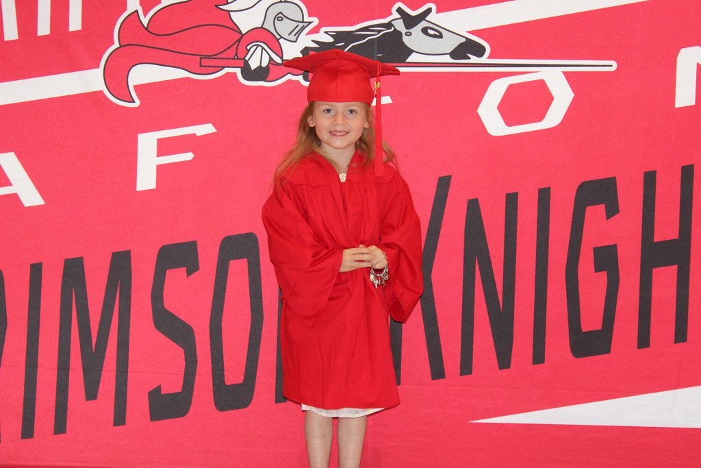 Afton student in front of Crimson Knight Banner