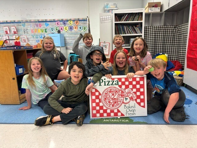 Students in photo with pizza box