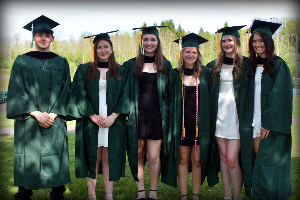 Six students who earned associate's degrees from Tompkins Cortland Community College pose for a photo in their graduation caps and gowns.