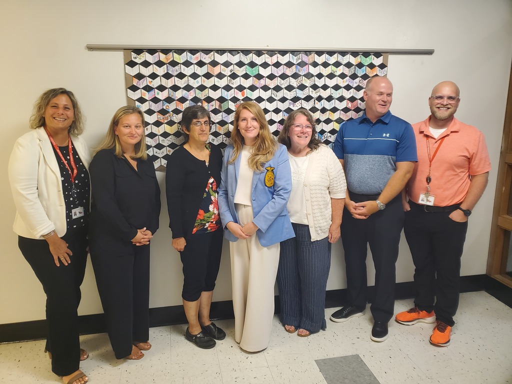 A group of Afton faculty and staff stand beside Cathleen Reeder after she is granted tenure