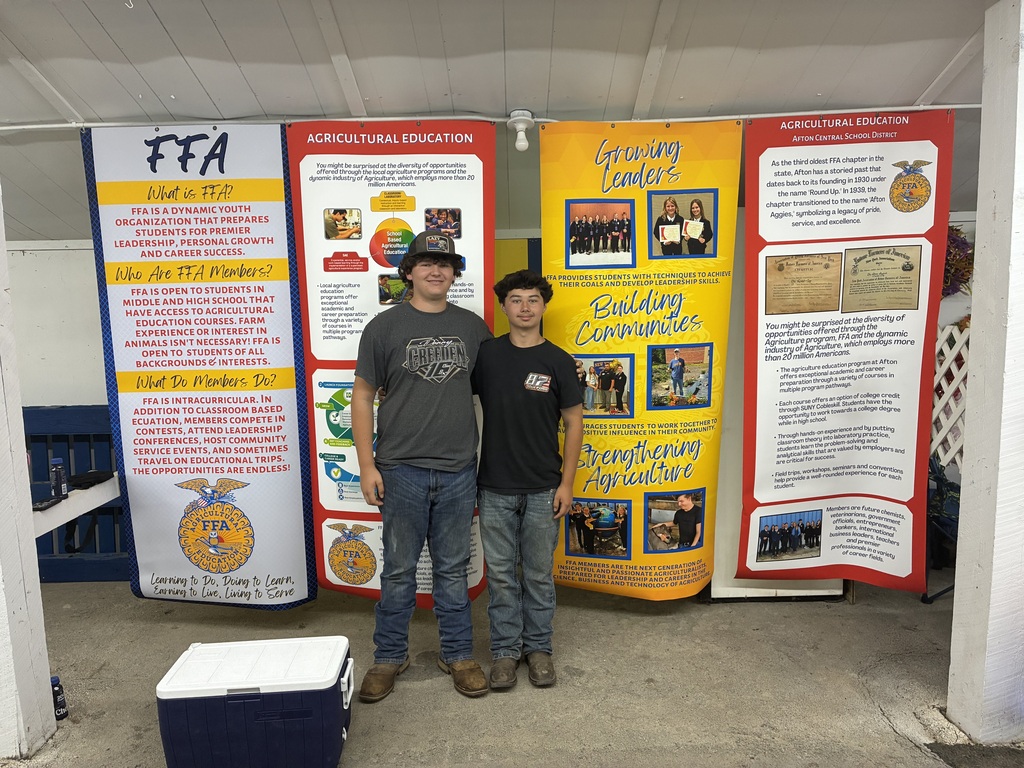 Two Afton FFA members pose for photo in their booth at the Afton Fair