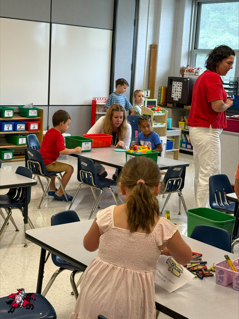 Pre-K and kindergarten students sit at various tables, working on arts and crafts and playing with toys around the classroom