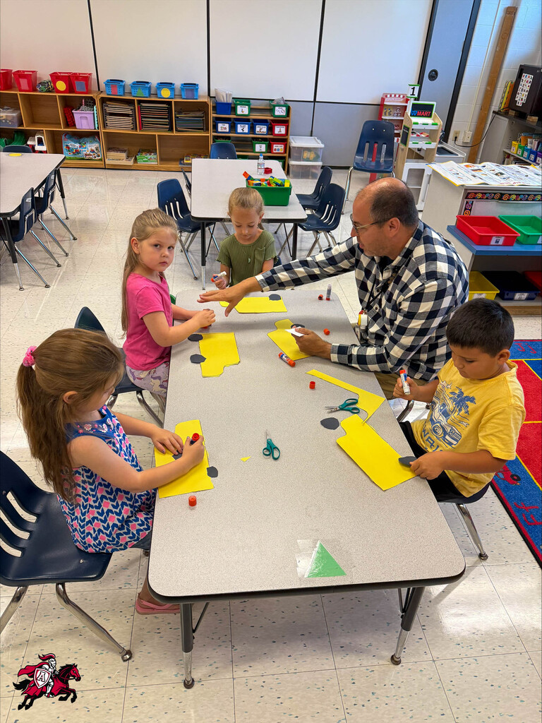 Pre-K and kindergarten students work on arts and crafts at a table