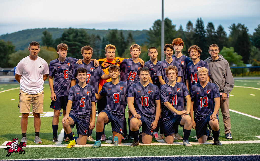 Soccer team standing together on a field. Players wear blue uniforms with numbers 5, 9, 10, and 13.