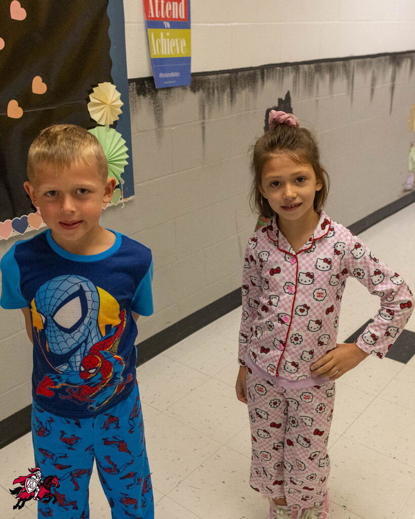 A young boy and girl standing next to each other. The boy wears a Spiderman outfit, the girl wears Hello Kitty pajamas.