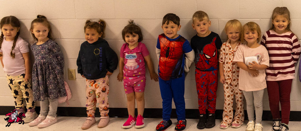 A group of young children, dressed in pajamas and shoes, standing in a line.