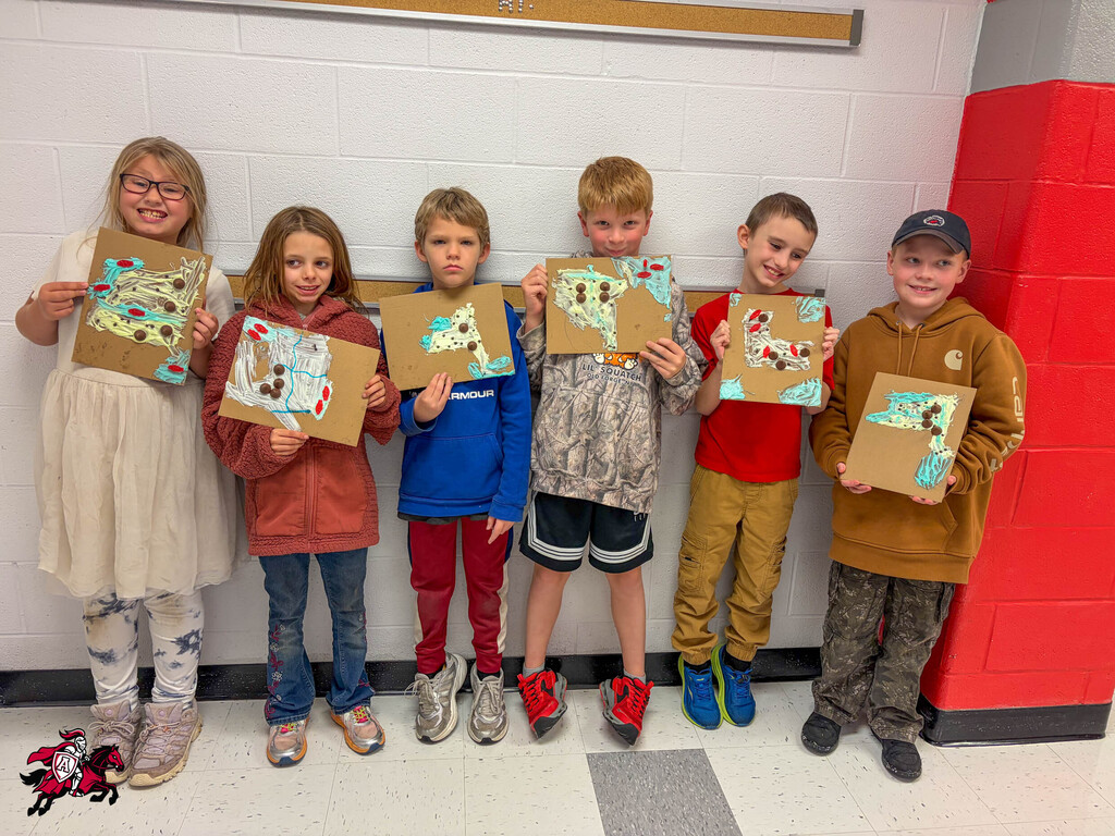 Six kids in a hallway, each holding a piece of artwork with different designs.