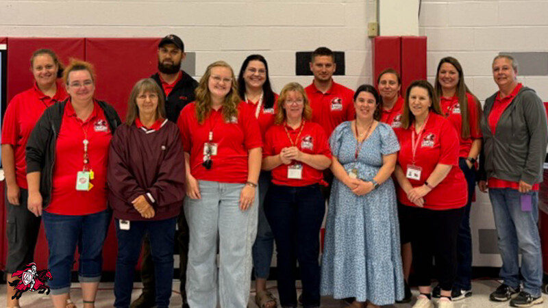 A group of Afton Central School District teachers, faculty and staff stand in two rows and smile for a photo