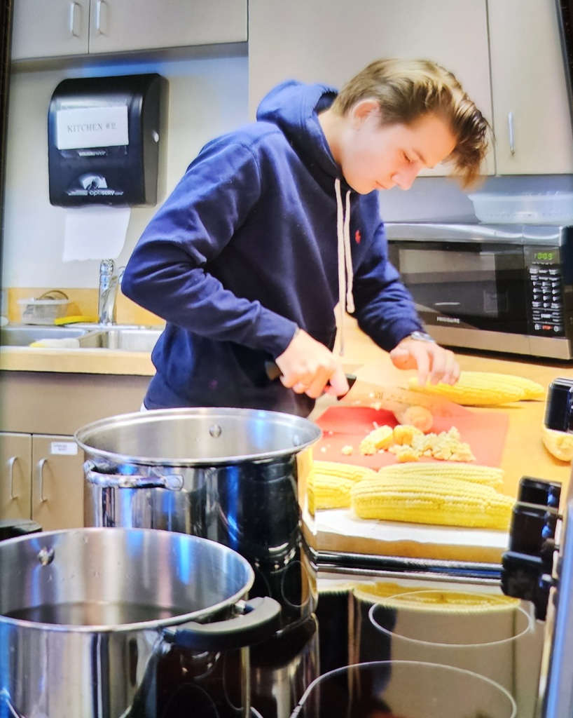 HS group cutting the ends off. It makes it easier to get the corn knobs in once it's cooked. 