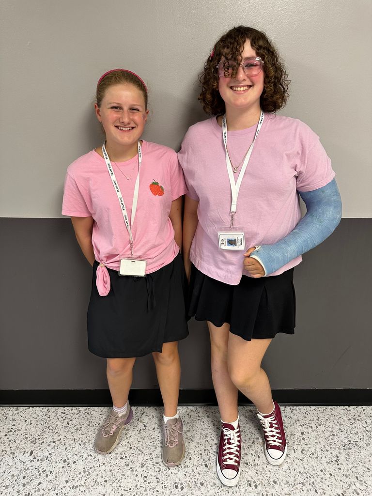 students dressed in pink tshirt and black skirts
