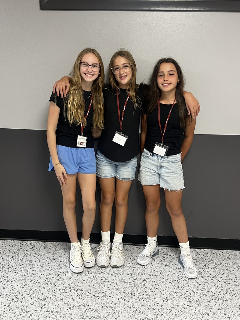 triplets wearing black tees and blue shorts