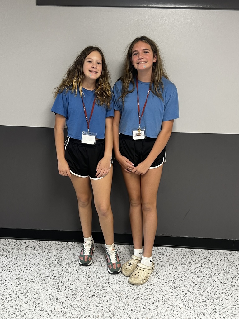 2 students wearing a blue shirt and black shorts