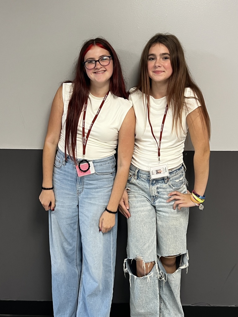 2 students wearing blue jeans and white tshirts