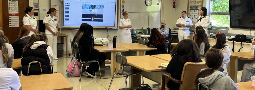 navy medical personnel talking to classroom of students