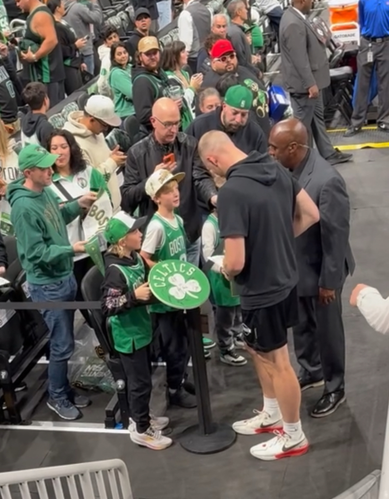 student getting homework signed by Celtics player