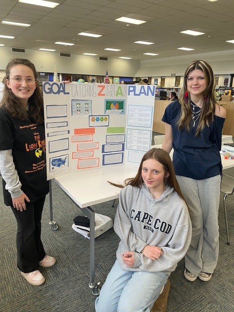 students standing with their completed civic posters