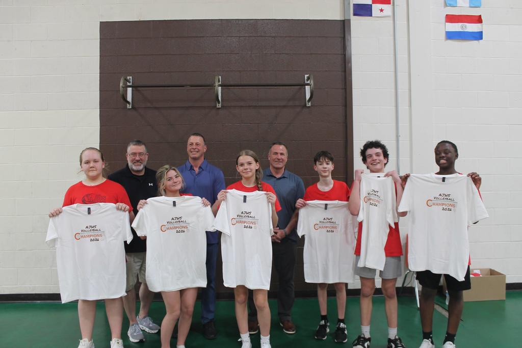 winning team posing with shirts and local dignitaries