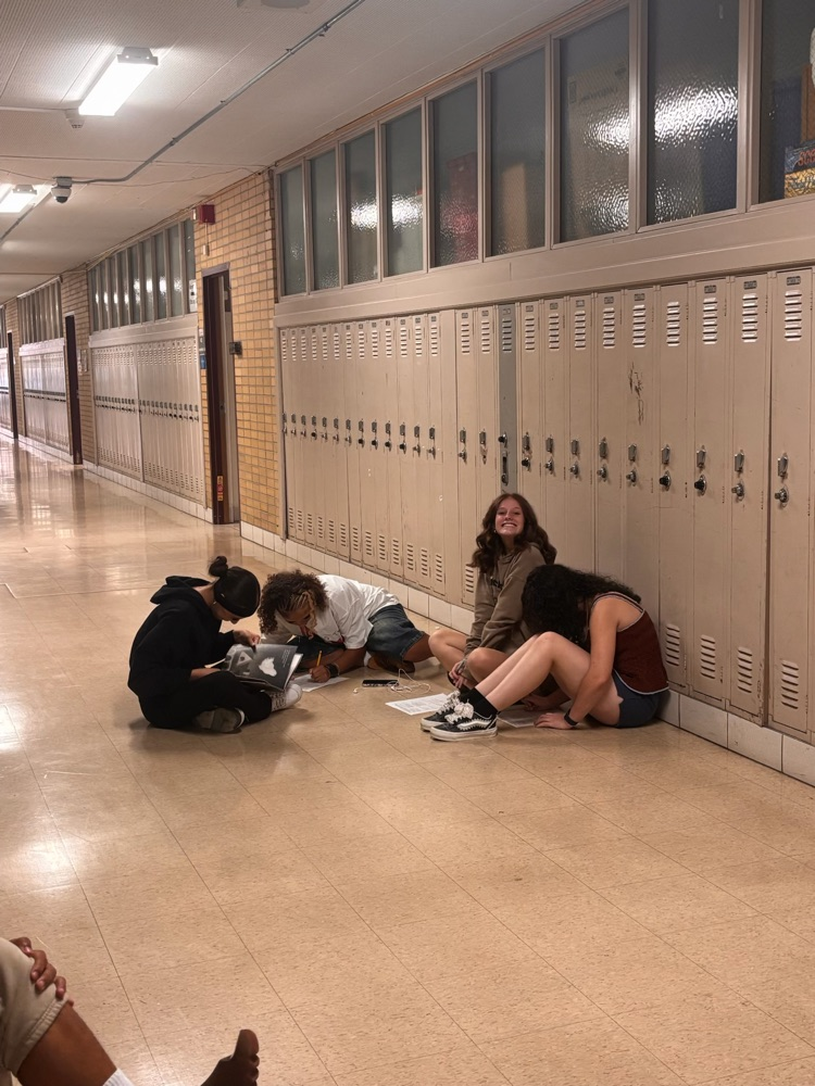 AHS students reading seated in the hallway