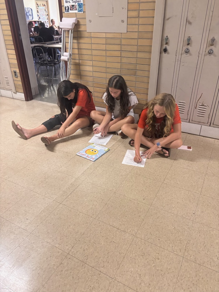 AHS students reading seated in the hallway