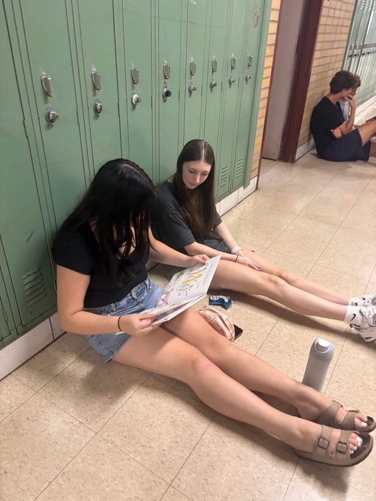 AHS students reading seated in the hallway