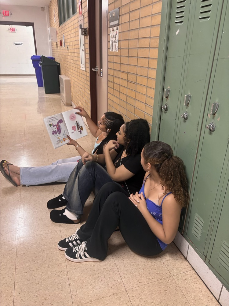 AHS students reading seated in the hallway