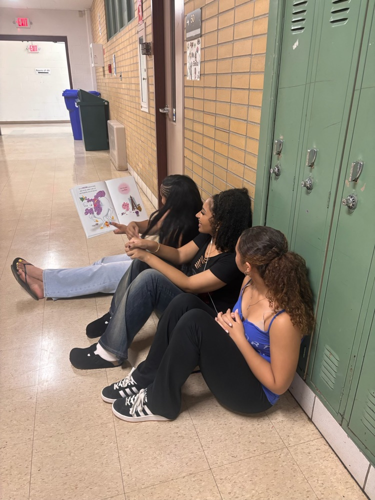 AHS students reading seated in the hallway