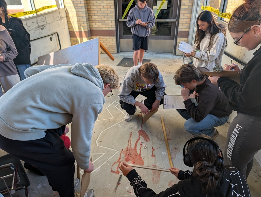 students in forensics science class examining a fake crime scene in the hallway