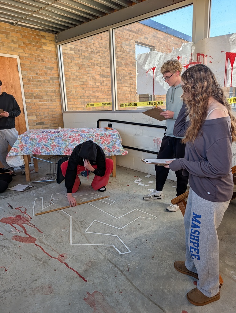 students in forensics science class examining a fake crime scene in the hallway