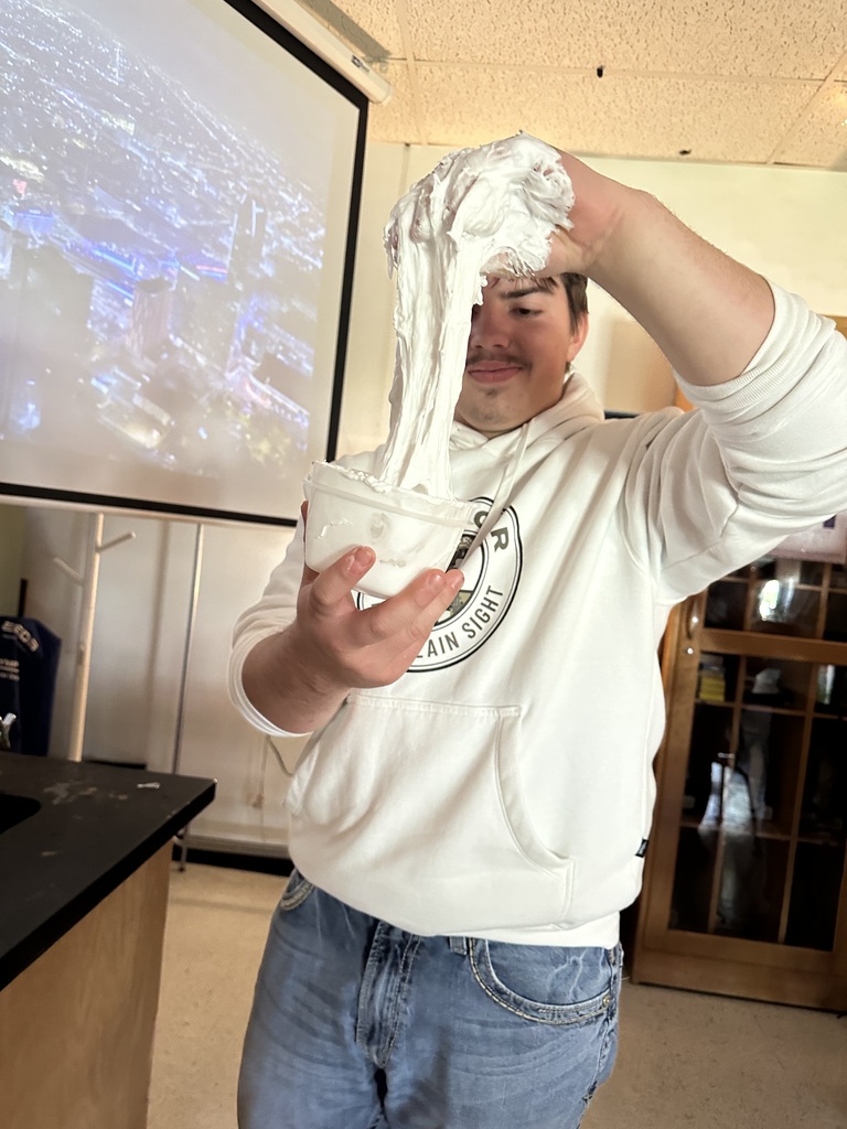 Student stretching slime to mix in all ingredients