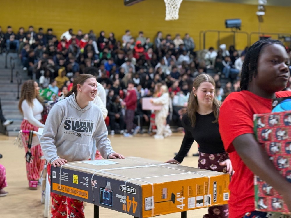 Students rolling a basketball goal to be given to a student for Christmas.